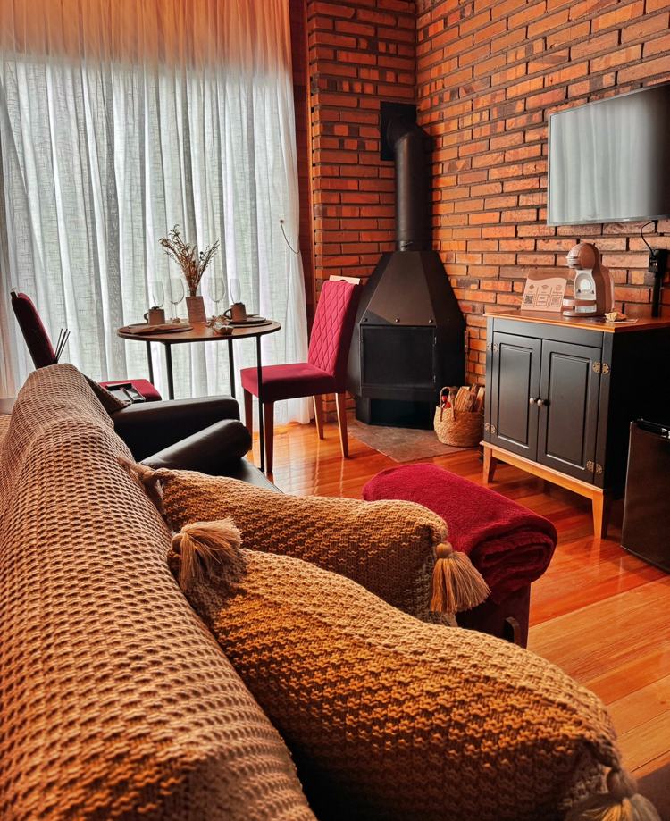 Sala da Cabana Charmat com sofá, poltronas e lareira