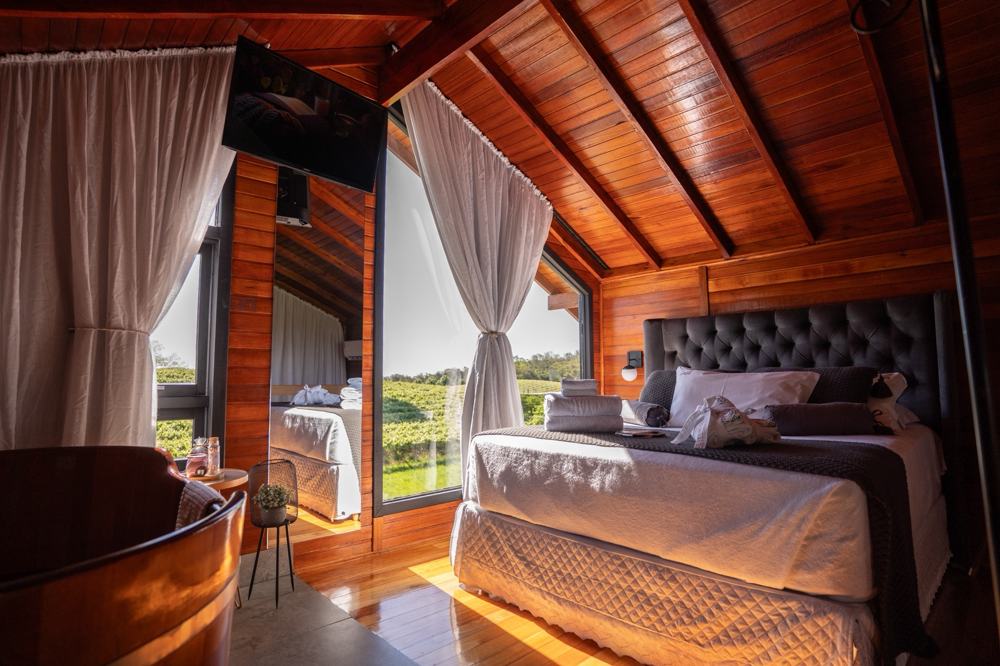 Ofurô de madeira e a cama na Cabana Premium
