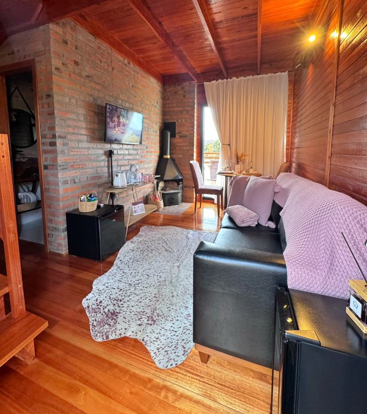 Sala da Cabana Rosé com sofá, tapete e lareira