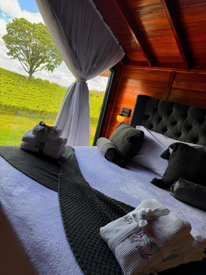 Cama com roupa de cama verde e a janela pro jardim