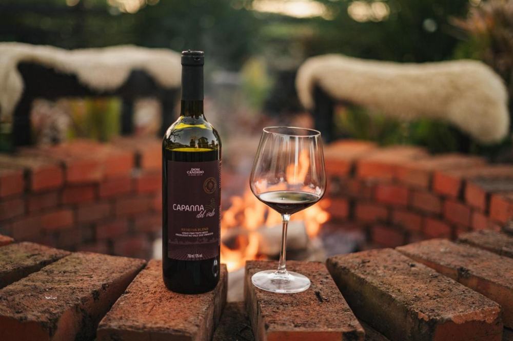 Garrafa de vinho Capanna del Vale e taça junto ao fire pit